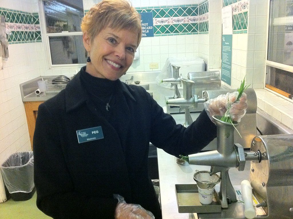 A person preparing fresh wheatgrass juice