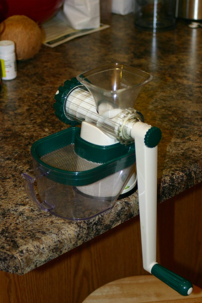 A hand-operated juicer on a countertop