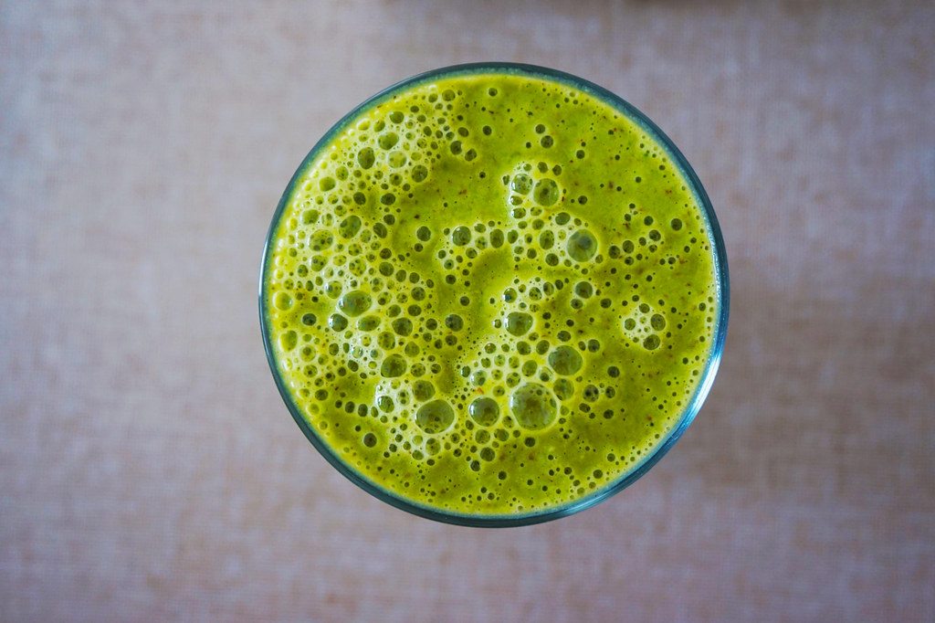 Green juice seen from above, with a foamy surface