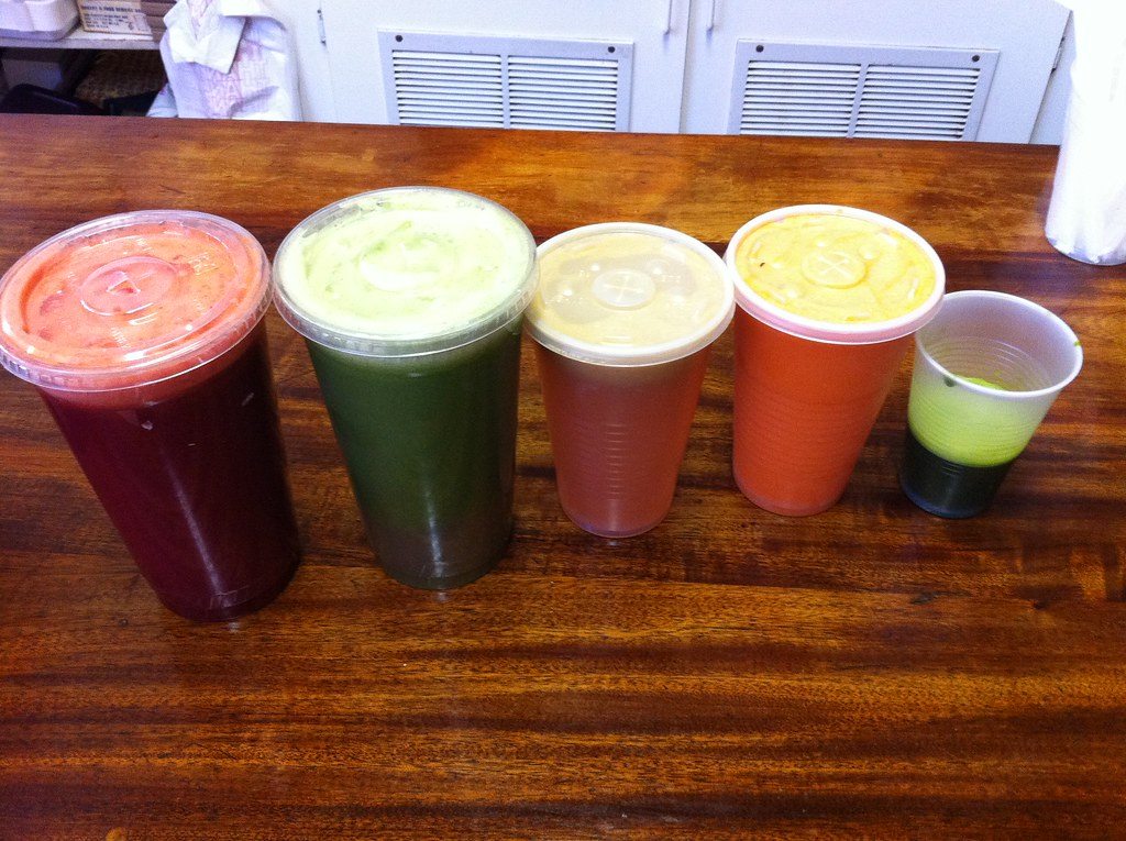 Fresh green wheatgrass juice served beside food